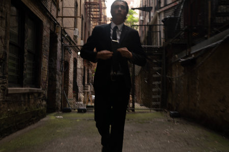 Young businessman walking in an old town. Wearing a suit and tie.の写真素材