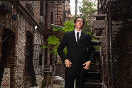 Handsome young man in a black suit standing on an abandoned buildingの写真素材