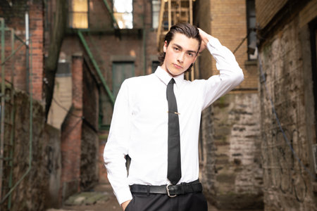 Young handsome businessman in white shirt and black tie posing in an old cityの写真素材