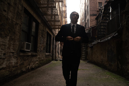 Handsome young man in a business suit standing in an old streetの写真素材