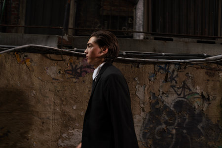 portrait of a young man in a black suit on the street