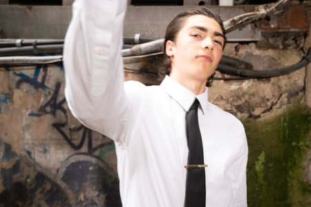 Portrait of a young business man standing in front of a wallの写真素材