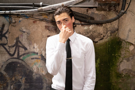 Young man in a white shirt and black tie on the street.の写真素材