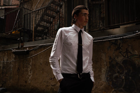 Handsome young man in a white shirt and black tie on a city streetの写真素材