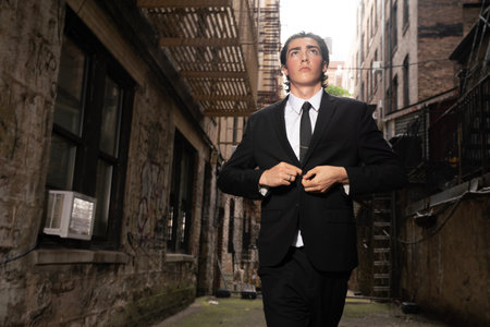 Young business man in a black suit and tie on an urban backgroundの写真素材