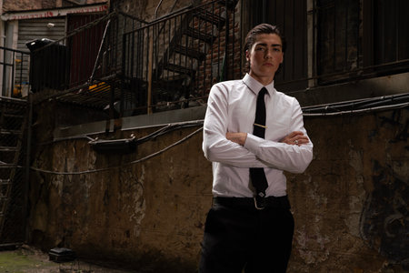 Portrait of a young businessman standing with arms crossed in an urban environmentの写真素材