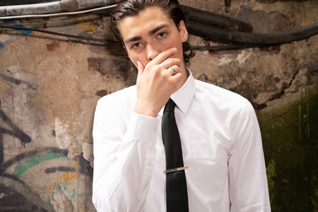 Portrait of a handsome young man in a white shirt and black tie
