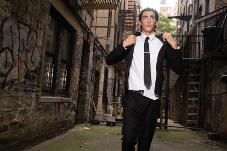 Handsome young man in black suit and tie posing in an urban contextの写真素材