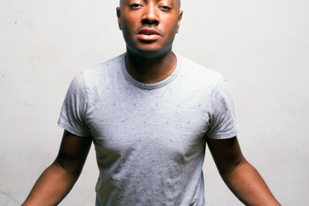 Young african american man in gray t-shirt on white backgroundの写真素材