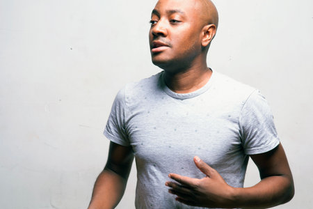 young handsome afro american man in white shirt on white backgroundの写真素材