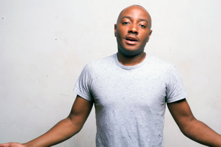 young handsome afro american man in white shirt posing emotional on white background, lifestyle people conceptの写真素材