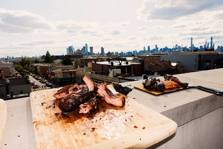 Roasted meat on a wooden cutting board with a view of the cityの写真素材
