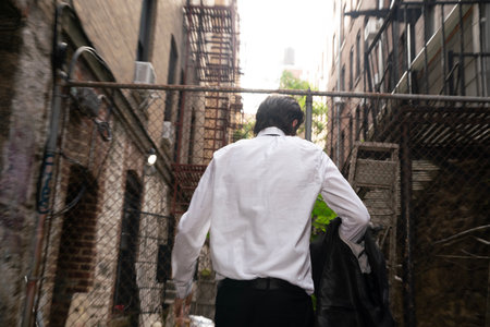 Businessman walking down the street with his back to the camera.