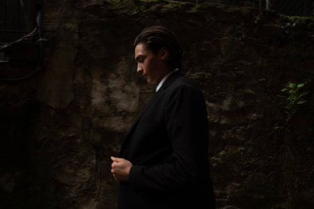 Portrait of a young man in a black suit on the streetの写真素材