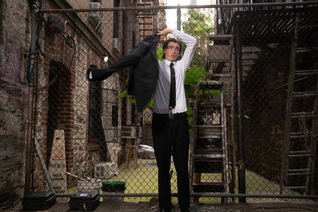 Young businessman in a business suit standing in an abandoned building and stretching his armsの写真素材