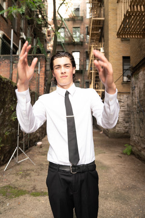 Handsome young man posing in a urban setting. Wearing a white shirt and black tie.の写真素材