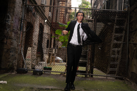 Portrait of a young business man standing outside in an abandoned buildingの写真素材