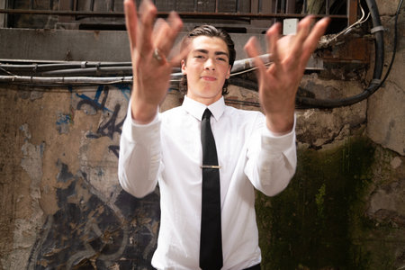 Young businessman in a white shirt and black tie with his hands up.の写真素材