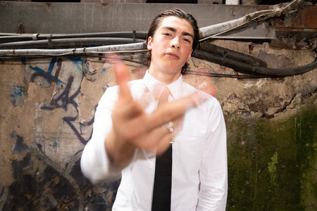 Portrait of a young business man showing gesture with grunge backgroundの写真素材