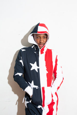 Portrait of a young man in a hoodie with American flagの写真素材