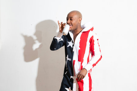 african american man drinking from a disposable cup on white backgroundの写真素材