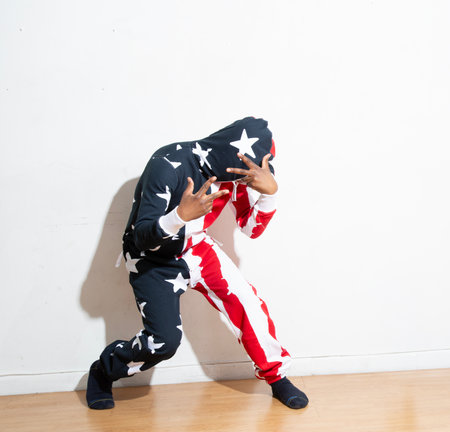 hip hop dancer posing on a white background with the american flagの写真素材