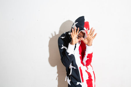 Portrait of a young man with American flag on white background.の写真素材