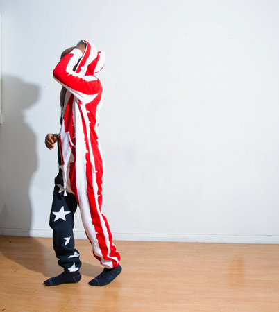 A boy in a clown costume with the American flag on his back.の写真素材