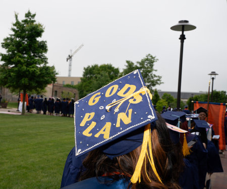 A high school graduate in a cap and gown at the graduation ceremony.の写真素材