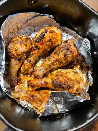 Grilled chicken legs with spices and herbs in baking pan, top viewの写真素材