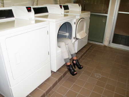 Laundry room interior with washing machine. Washing machine and womanの写真素材