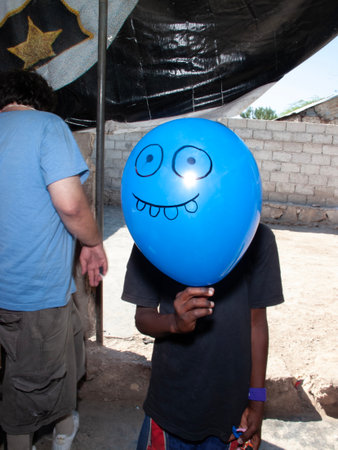 Unidentified indian boy holds a blue balloon with a funny face.の写真素材