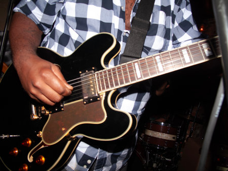 Guitarist playing a guitar in a nightclub, close-upの写真素材