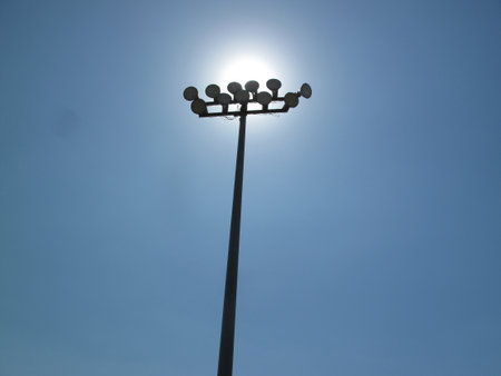 Lamp post on blue sky background. Street light pole with sun.の写真素材