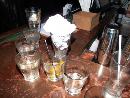 Cocktail shaker and glasses on a table in a barの写真素材