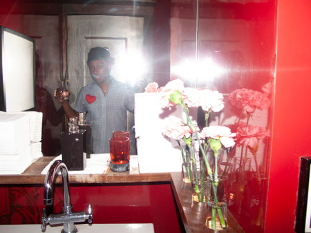 man in a nightclub with flowers in front of him and a mirrorの写真素材
