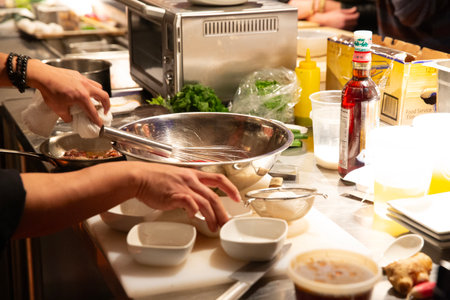 Chef preparing food in a commercial kitchen, closeup of handsの写真素材