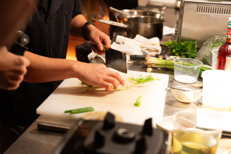 Chef cooking in a restaurant kitchen, close-up of hands