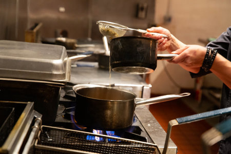 chef at work in a restaurant kitchen preparing food, meal or dinnerの写真素材