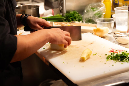 Chef at work in a restaurant kitchen, preparing and decorating foodの写真素材