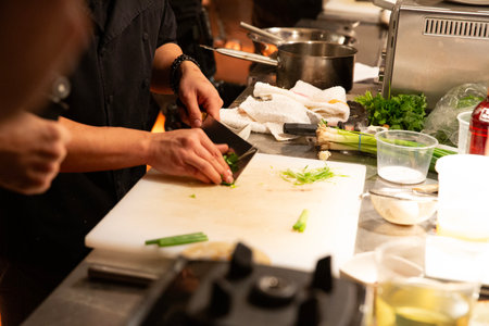 Chef cutting vegetables in a commercial kitchen, close-up.の写真素材
