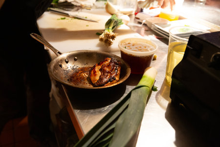 Grilled meat in a frying pan on a table in a restaurantの写真素材