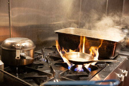 Cooking in a pot on a gas stove in a restaurant kitchenの写真素材