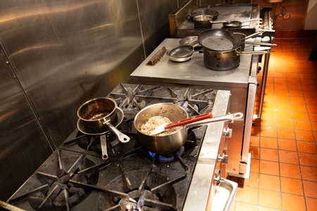 pot with boiling water on a gas stove in a restaurant kitchen.の写真素材