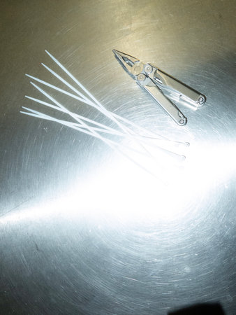 a pair of pliers and tweezers on stainless steel background.