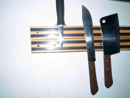 Knife and cutting board on the white wall in the kitchen.の写真素材