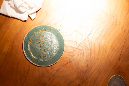 Dirty plate on a wooden table. Top view, copy spaceの写真素材