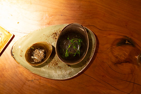 Plate with sprouts and herbs on a wooden table in a restaurantの写真素材