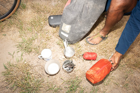 Man pouring milk from a bottle to a cup on the ground.の写真素材