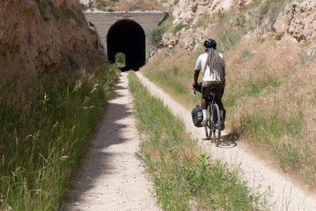 Cyclist with a backpack and bicycle on the road to the tunnelの写真素材